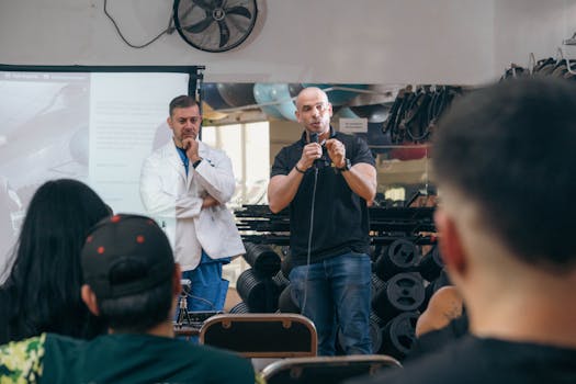 Membership A doctor and fitness trainer conducting a seminar in a gym setting.