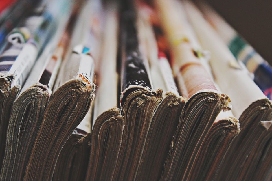 Newsletter A detailed close-up image of a stack of magazines arranged in a row, showcasing their bindings.