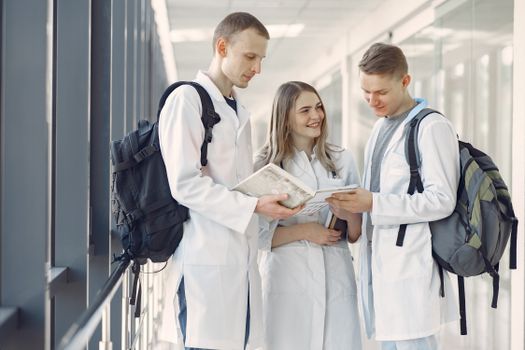 Membership A group of medical students in white coats studying together in a hospital hallway.